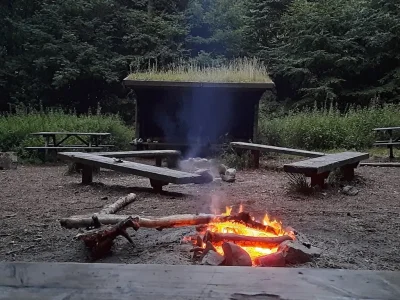 Un feu de camp allumé devant un shelter