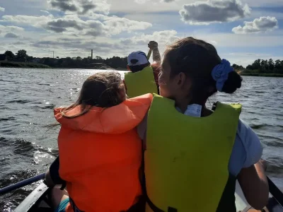 Des enfants avec leurs gilets gonflables font du canoé sur un lac