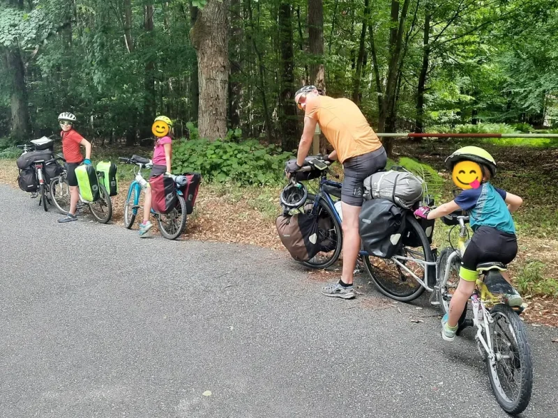 une famille de cyclotouristes dans la forêt avec les vélos chargés