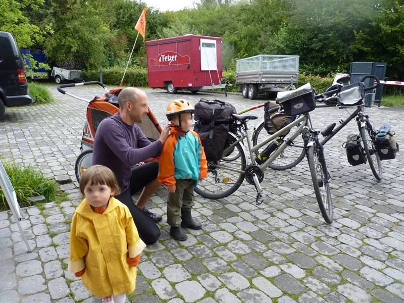 Papa équipe les enfants pour un départ sous la pluie